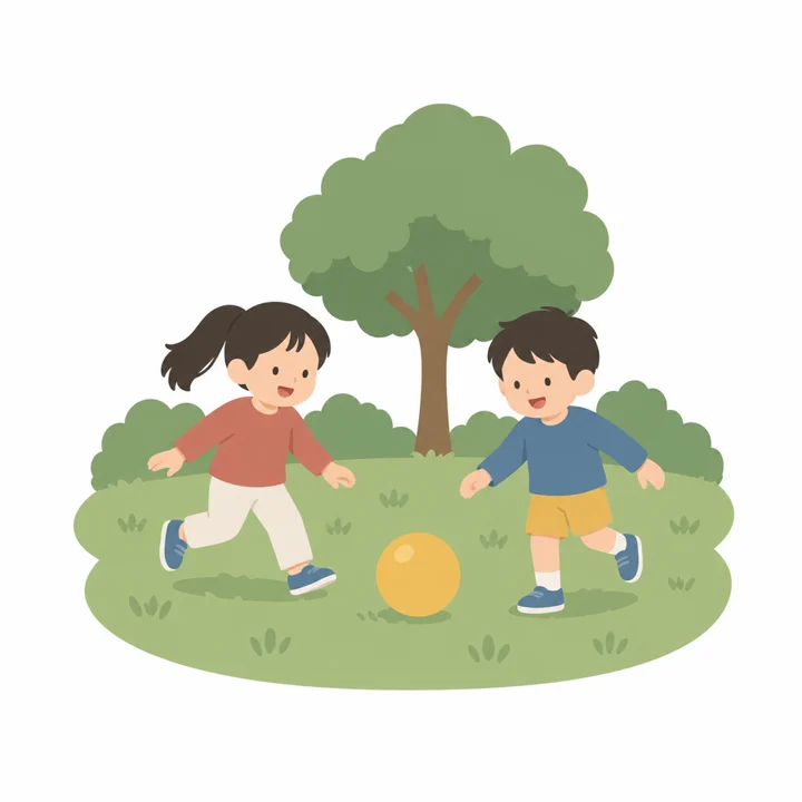 Two children, a girl and a boy, run after a yellow ball on the grass in a park.